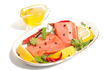 Pieces of lightly salted trout with spices, olive oil and lemon isolated on white background