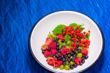 raspberries, currants, gooseberries, fresh fruits on background