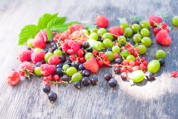 raspberries, currants, gooseberries, fresh fruits on background
