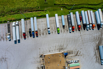 An aerial top view of parking trucks at a rest area on the highway
