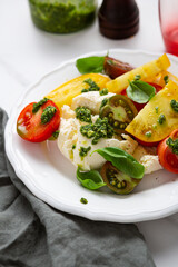 Close up of tomato and buratta chesese salad pesto dressing