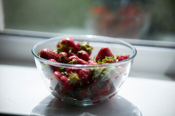 Strawberries in a glass plate close-up. Seasonal berry. 