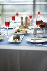The table is set. Red wine in glasses on the table. Festive table setting  