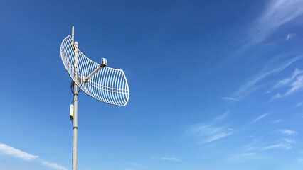 Outdoor internet wifi receiver and repeater antenna on the roof of the building with clear bluesky...