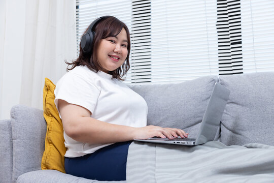 Chubby Woman Using Her Laptop on a Couch
