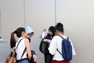 Four group young attractive Asian multi ethnic woman friends colleagues students talk walk discuss...
