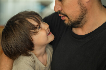 the faces of the father and son are close-up, the father spends time with his son, he talks to him, they laugh and smile, the concept of a happy family