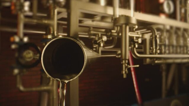 Vodka pouring from big tubes inside professional alcohol production factory . Process of distillation . Camera moving inside pipe . Close up slow motion . Shot on ARRI ALEXA Camera with Laowa lens
