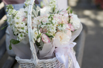 Bouquet of delicate flowers in a white basket 