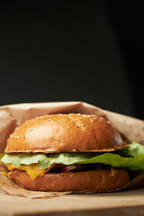 Burger on a turf board. Burger with brioche, beef, slat romaine, tomato, cucumber, cheddar cheese and onion.  