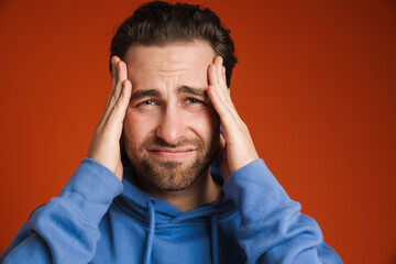 Young bristle man with headache rubbing his temples