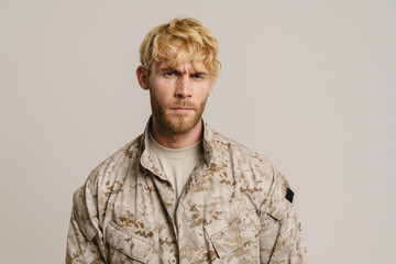 White military man wearing uniform frowning and looking at camera