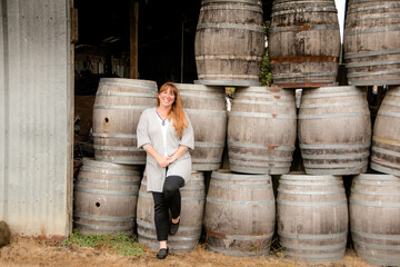 Woman standing by Wine barrels