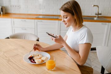 Smiling young woman having healthy breakfast
