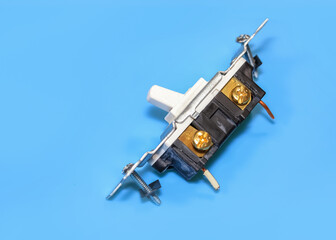 Broken electrical switch on blue background.