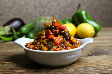Olive Salad served in a dish side view on wooden table background