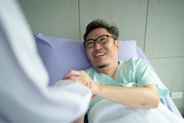 Doctor holding touching hands Asian senior male patient with love, care, helping, encourage and empathy at nursing hospital ward, healthy strong medical concept