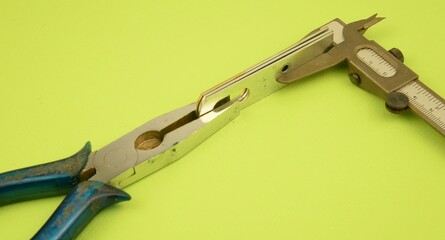 Attrezzi e materiali per il laro manuale: pinza, staffa e calibro in metallo
