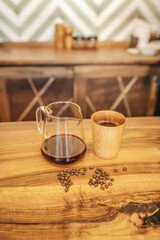Jug cup with coffee and coffee beans on table