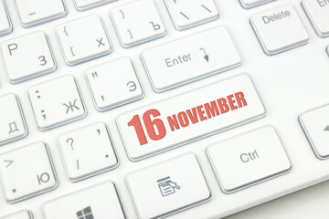 November 16th. Day 16 of month, Calendar date. Cropped view of Modern White Computer Keyboard with calendar date. Concept workspace, freelance, deadline.  Autumn month, day of the year concept.