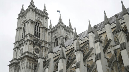 View from the bottom on the Westminster Abbey exterior details against the grey cloudy sky. Action....