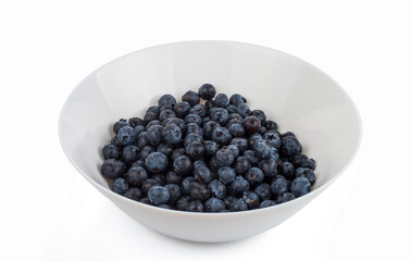 Washed large ripe blueberries in a white bowl. isolated on white background.