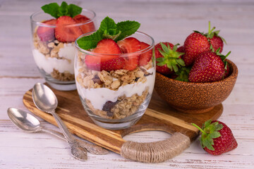 Two strawberry desserts with yogurt and granola.