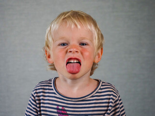 Portrait face funny boy blonde hair. Funny emotional child with an expression of various emotions
