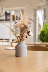 Vases with bouquet of dry flowers on wooden table. Minimalist in cafe interior design. Kinfolk or scandinavian style. Cozy cafe design.