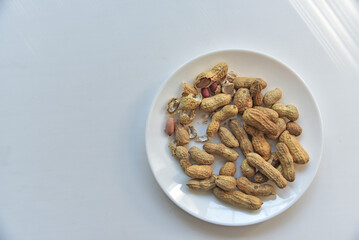 Nuts peanuts in a shell on a white plate
