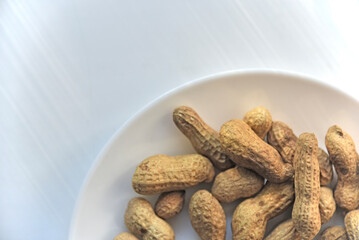 Nuts peanuts in a shell on a white plate