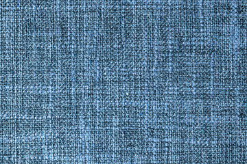 Close-up texture of natural blue coarse weave fabric or cloth. Fabric texture of natural cotton or linen textile material. Blue canvas background. Decorative fabric for upholstery, furniture, walls