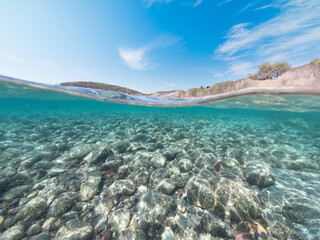 Fototapeta na wymiar Split underwater view of La Speranza rocky seabed under a shining sun