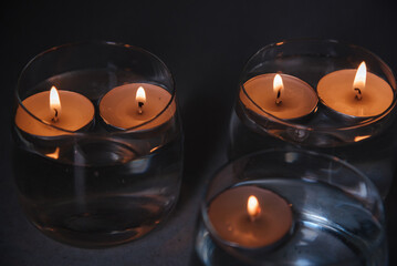 lit candles on water in candlesticks