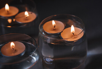 lit candles on water in candlesticks