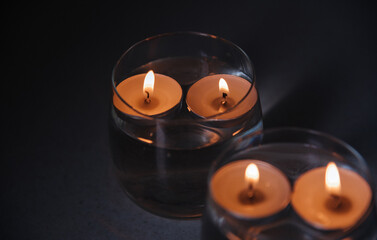 lit candles on water in candlesticks