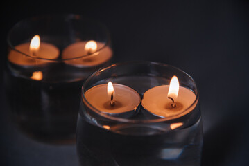 lit candles on water in candlesticks