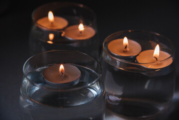 lit candles on water in candlesticks