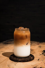 Cold iced latte coffee. A tall highball glass filled with ice cubes, layered refreshing drink - 512655748
