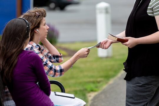 Woman On Park Bench Being Handed A Gospel Tract