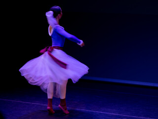 Bailarina clásica con tutú blanco sobre el escenario