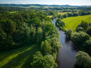 Aerial shot of forest, river and hills in background