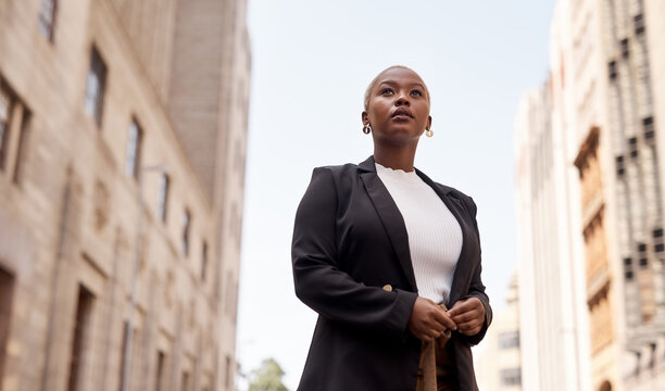 I wont stop till I realise my dream. Low angle shot of a young businesswoman looking thoughtful while standing in the city.