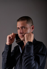 A young man turning up the collar of his shirt