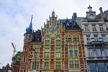 Fototapeta na wymiar Pharmacie Anglaise in historic mansion with tower, product names in gold, red-white facade, bluish roof and sun dial on Koudenberg in central Brussels, Belgium