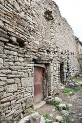 Fototapeta na wymiar ruined stone houses on the street in abandoned mountain village Old Koroda in Dagestan, Russia
