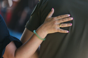 A woman holds a hand on the back of her husband