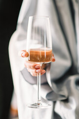 Morning of the bride. bride in a wedding dress. Gentle hands of the bride holding a glass of champagne.