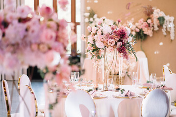 Flower table decorations for holidays and wedding dinner. Table set for holiday, event, party or wedding reception in a restaurant.