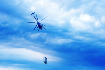 Fototapeta na wymiar Bottom view of helicopter with cargo flying in the dramatic sky